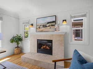 Living area with a tiled fireplace and wood finished floors