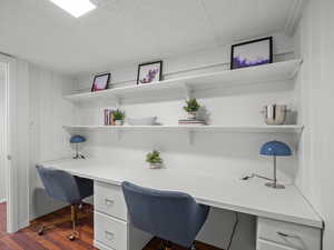 Office space featuring built in study area and dark wood-style floors