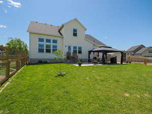Rear view of house with a gazebo, a patio area, and roof with shingles