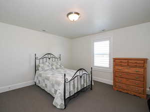 Bedroom featuring dark carpet and baseboards