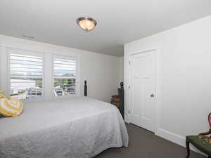 Bedroom with dark carpet and baseboards