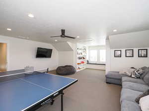 Game room with recessed lighting, carpet, a ceiling fan, a textured ceiling, and built in features