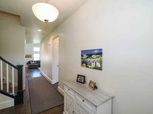 Hall featuring baseboards, stairway, dark wood finished floors, and recessed lighting