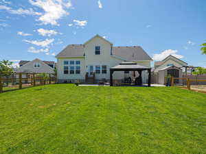 Back of property featuring a gazebo, a patio area, and roof with shingles