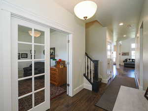 Hallway featuring wood finished floors, baseboards, stairs, and recessed lighting