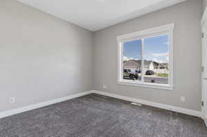 Carpeted empty room with baseboards