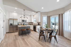 Dining room featuring recessed lighting, lofted ceiling, and light wood-type flooring