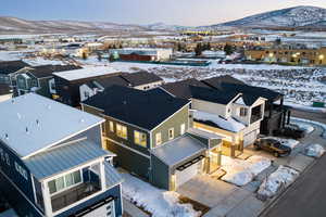 Snowy aerial view with a mountain view and a residential view