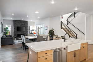 Kitchen featuring a sink, dishwasher, healthy amount of natural light, light brown cabinetry, and recessed lighting