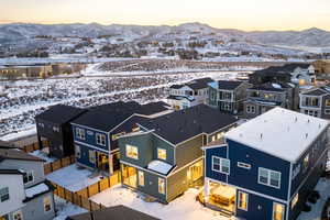 Snowy aerial view featuring a mountain view and a residential view