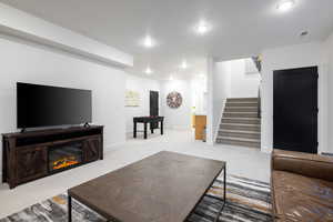 Living area featuring stairway, light carpet, recessed lighting, and baseboards