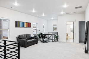 Living room featuring light colored carpet, attic access, baseboards, and recessed lighting