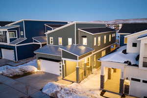 View of front of home with metal roof, a standing seam roof, an attached garage, and concrete driveway