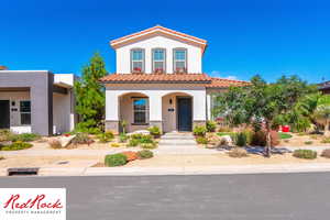 Mediterranean / spanish-style house featuring stucco siding, a tile roof, a porch, and stone siding