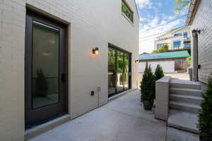 View of exterior entry featuring a patio area between the home and garage at Mud Room entry