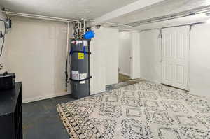 Finished basement featuring secured water heater and baseboards
