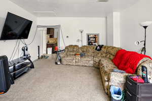 Living room with carpet floors and attic access