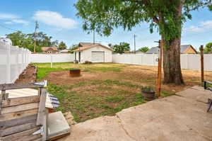Fenced backyard with a garage and a patio