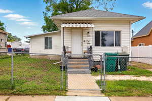 View of front of home with a gate and a shingled roof