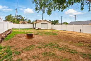 View of yard with a detached garage and an outbuilding
