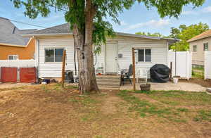 Back of house featuring roof with shingles
