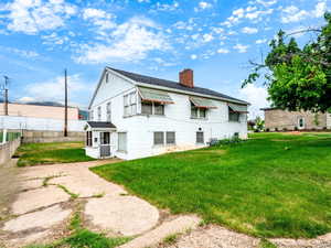 Rear view of house with a chimney and a shingled roof