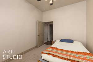 Bedroom with light colored carpet, ceiling fan, baseboards, and a towering ceiling