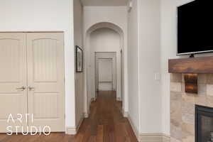 Corridor with arched walkways, wood finished floors, and baseboards