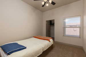 Carpeted bedroom featuring ceiling fan and baseboards