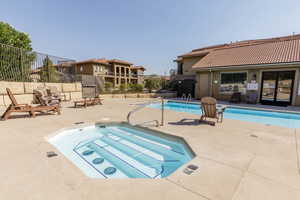 Community pool with a patio and a community hot tub