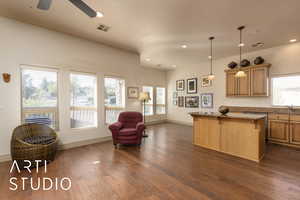 Kitchen with a kitchen island, a sink, dark wood-style floors, plenty of natural light, and recessed lighting