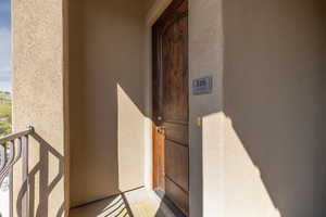 Doorway to property featuring stucco siding