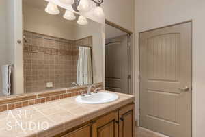 Full bath featuring curtained shower, vanity, and tile patterned floors