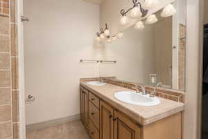 Bathroom with double vanity and light tile patterned floors