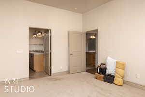 Bedroom with light carpet, baseboards, and a spacious closet