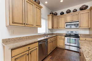 Kitchen featuring stainless steel appliances, light stone countertops, dark wood-style flooring, and recessed lighting