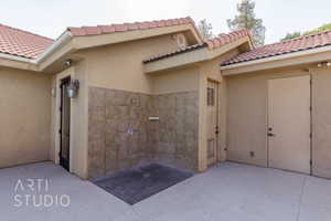 View of exterior entry featuring stucco siding and a tile roof