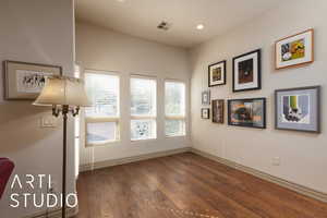 Empty room featuring wood-type flooring, baseboards, and recessed lighting