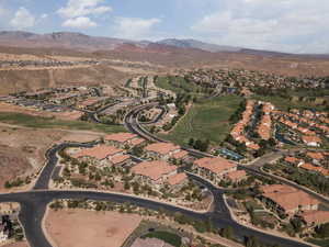 View of property location featuring a mountain backdrop, nearby suburban area, and a golf course