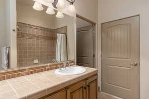 Full bath with vanity, a shower with curtain, and light tile patterned floors