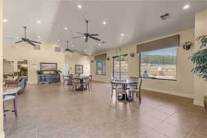 Dining area featuring light tile patterned flooring, high vaulted ceiling, and recessed lighting