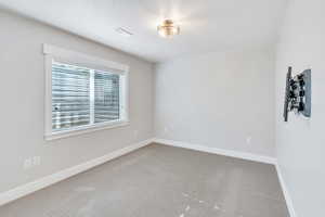 Carpeted empty room featuring baseboards