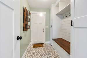 Mudroom featuring baseboards and light flooring