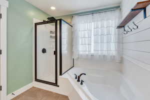 Bathroom with a stall shower, tile patterned floors, a bath, baseboards, and recessed lighting