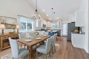Dining room featuring high vaulted ceiling, a chandelier, recessed lighting, and light wood finished floors