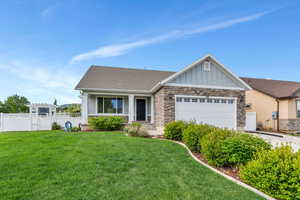 View of front of property with stone siding, board and batten siding, a garage, a pergola, and concrete driveway