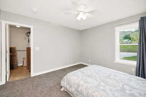 Carpeted bedroom with baseboards and a ceiling fan
