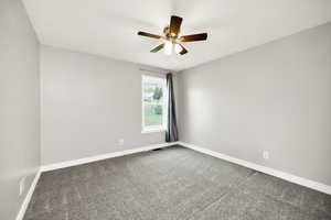 Spare room featuring carpet, baseboards, and a ceiling fan