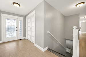 Entryway featuring wood finished floors, baseboards, and a textured ceiling