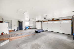 Garage featuring freestanding refrigerator and a garage door opener